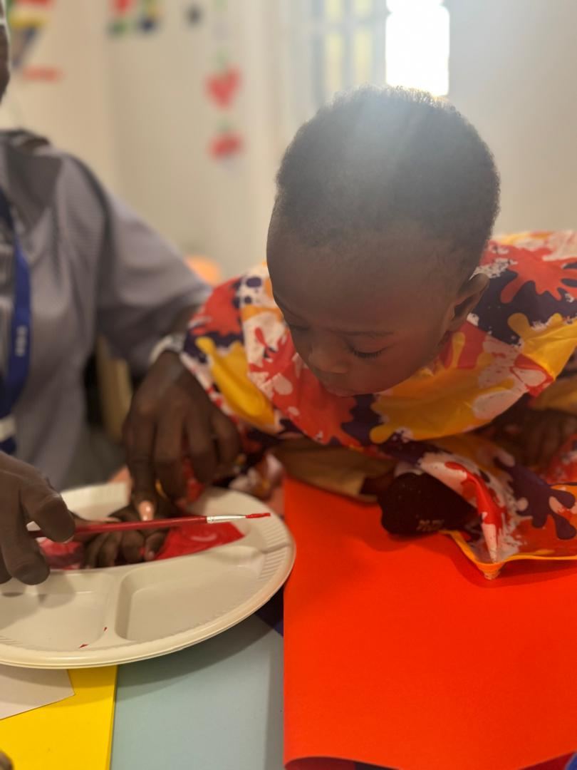 Nursery child focused on a painting activity