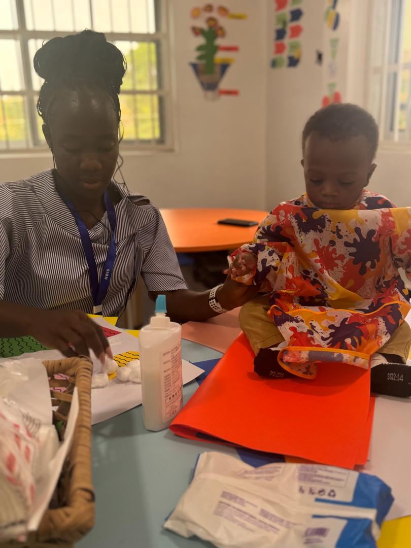 HoneyBerry teacher supporting a young child during art work